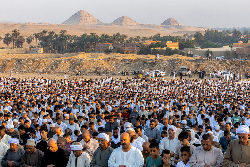 Muslim worshippers perform the early morning prayers for Eid al-Adha, the feast of sacrifice, near the ancient Egyptian Abusir pyramids necropolis in the village of Abusir in the south of Giza province on June 6, 2025. (Photo by Mahmoud el-KHAWAS / AFP) (Photo by MAHMOUD EL-KHAWAS/AFP via Getty Images)