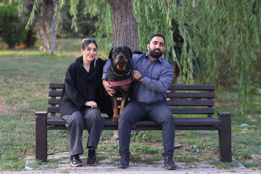 An Iranian couple sit with their dog in a park in Tehran on June 8, 2025. Iranian authorities have expanded a ban on walking dogs in public to multiple cities nationwide, citing public health, social order and safety concerns, domestic media reported on June 8. Owning and walking dogs has been a contentious topic since the 1979 Islamic revolution in Iran, though there is no law outrightly banning dog ownership. (Photo by ATTA KENARE / AFP) (Photo by ATTA KENARE/AFP via Getty Images)