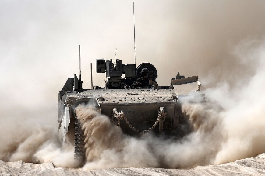 An Israeli army armoured personnel carrier moves at a position in southern Israel along the border with the Gaza Strip