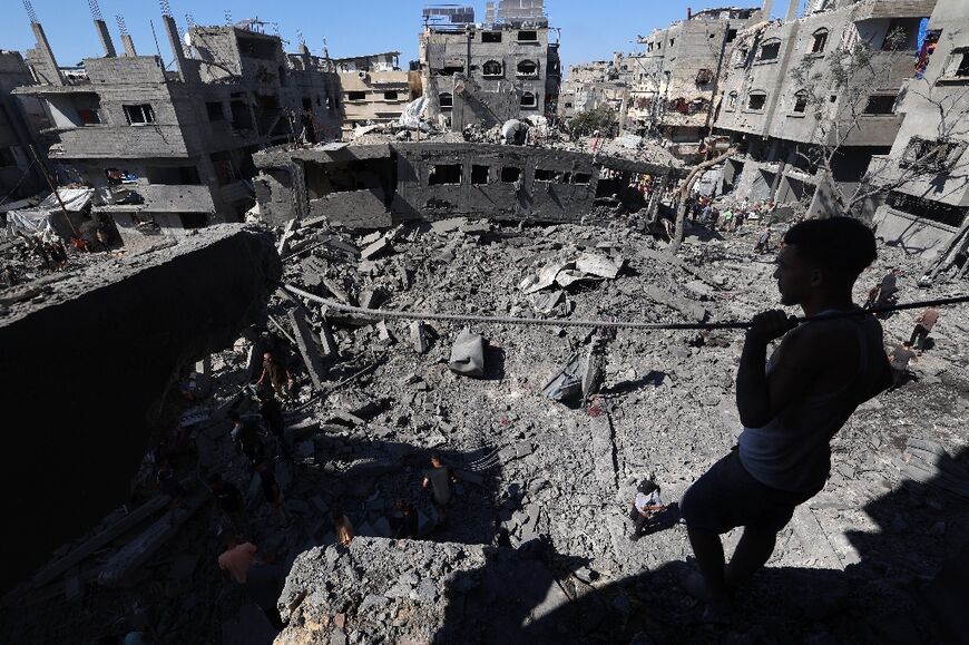 A Palestinian inspects the damage after an Israeli strike on Al-Bureij refugee camp in the central Gaza Strip.