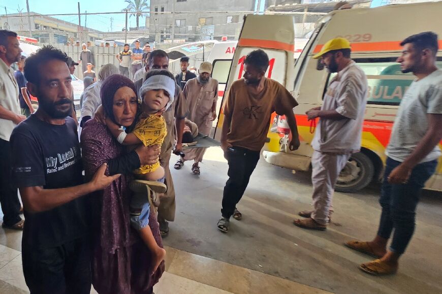 Palestinian carry their child wounded in an Israeli strike on a camp for displaced people near Khan Yunis, as they arrive at the Nasser Hospital in the southern Gaza Strip city on July 8, 2025. 