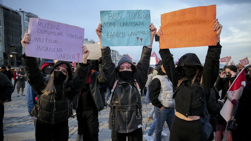Protesters hold signs during a demonstration in Izmir, Turkey, on March 24, 2025. 