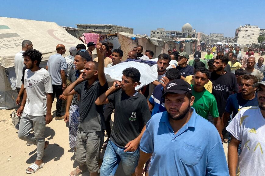 Mourners carry the body of one of the journalists killed in an Israeli strike on Nasser hospital Monday