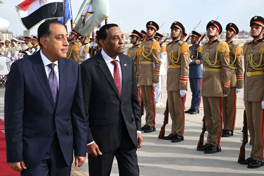 Egypt's Prime Minister Mostafa Madbouly (L) welcomes his counterpart from Sudan Kamil Idris, on his first foreign trip since taking office
