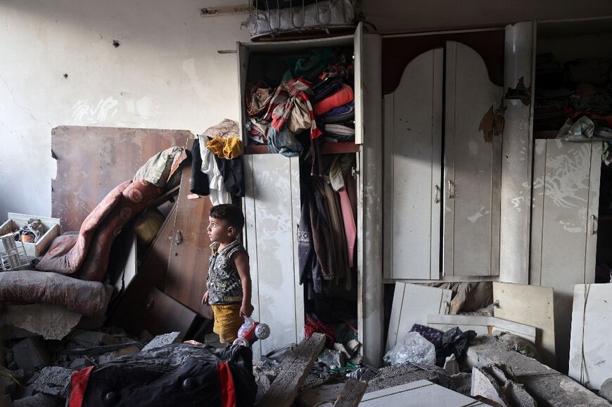 A Palestinian child holds a toy car that he recovered from a house damaged by an Israeli strike