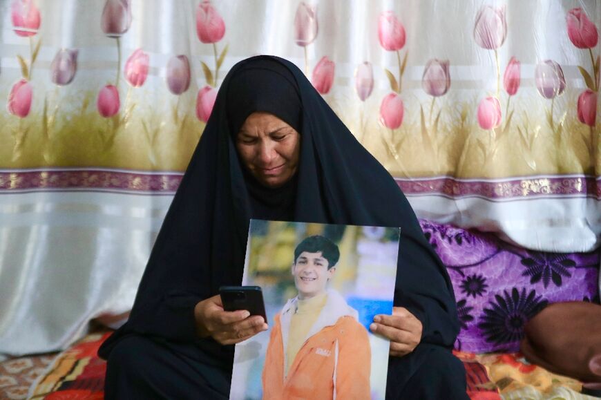 Zeinab Jabbar, 54, cries as she looks at a video of her missing son Mohammed