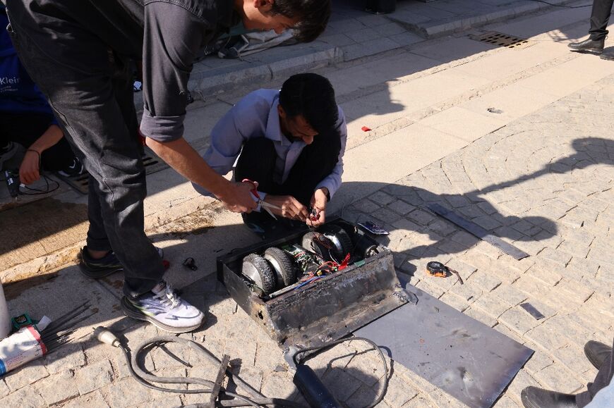 Engineering students prepare their robot for a battle event at Iran's Tech Olympics