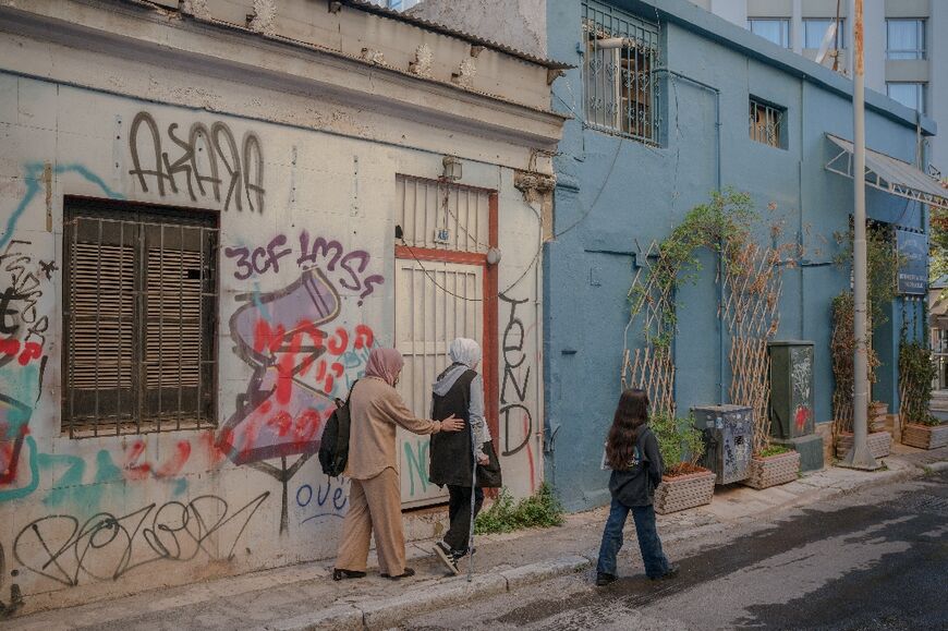 Raghad al-Fara, 15 (C), walks with crutches because of severe injuries she suffered in an Israeli bombing raid