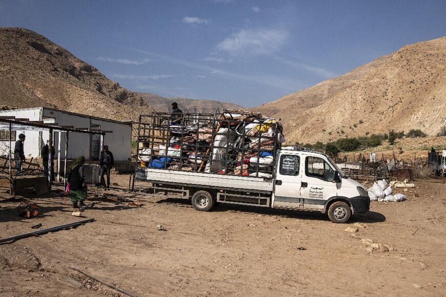 Men help load belongings onto a truck as a Bedouin family leave their home in the West Bank