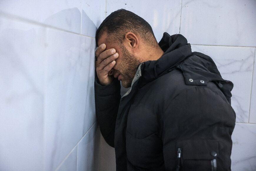 A family member weeps next to the bodies of the Palestinian journalists killed in an Israeli strike