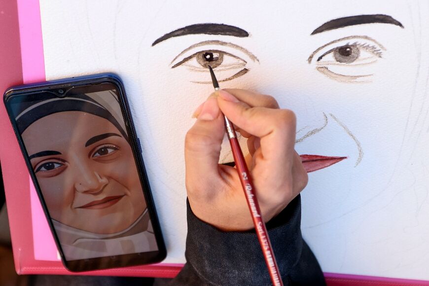 A protester draws a portrait of Mahdieh Esfandiari, an Iranian woman who was handed one year in prison for justifying terrorism in France