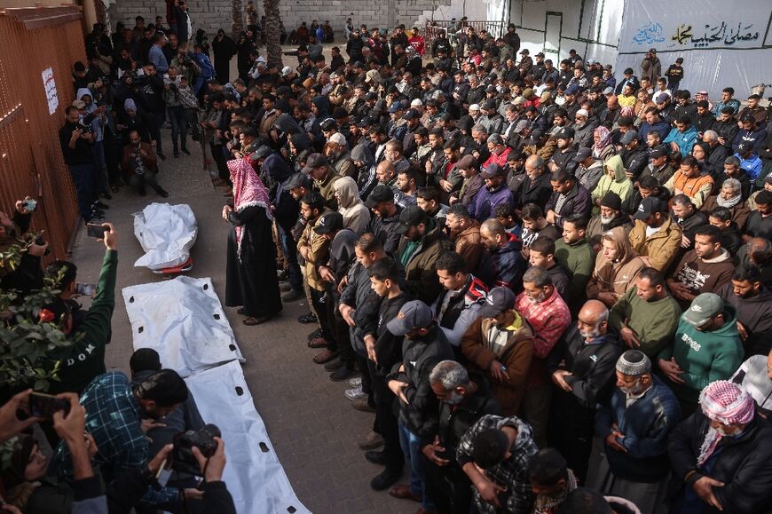 Mourners pray at Nasser Hospital in Khan Yunis over the bodies