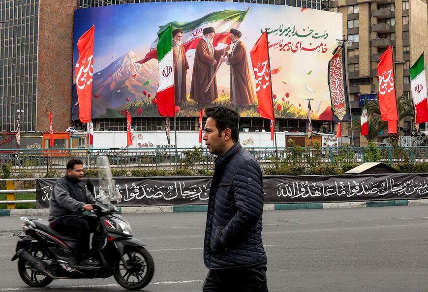 A billboard showing Mojtaba Khamenei receiving the national flag from his father, watched over by founder Ruhollah Khomeini 