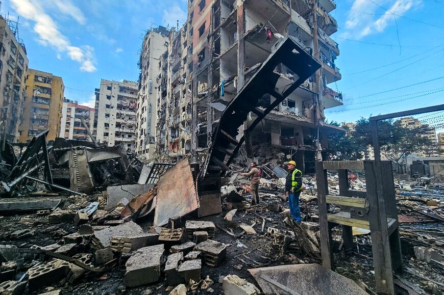 Men inspect a site of overnight Israeli airstrikes in the southern suburbs of Beirut on March 16, 2026