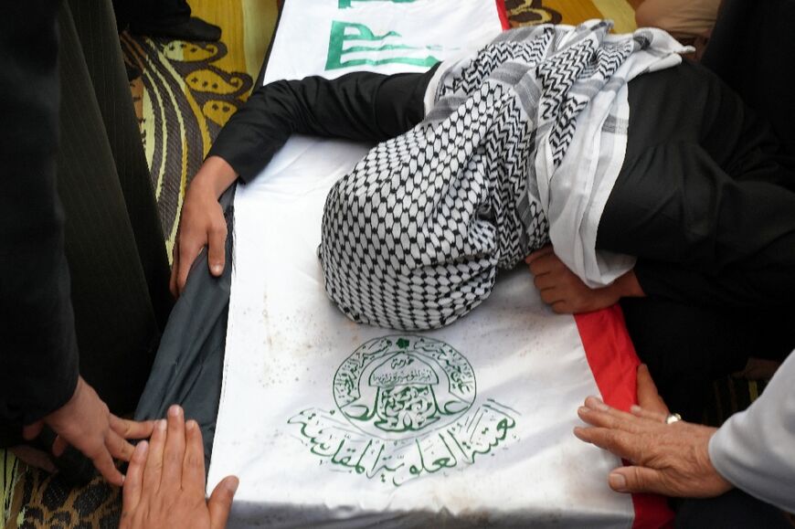 A family member mourns over the coffin of one of those killed at the Habbaniyah military base