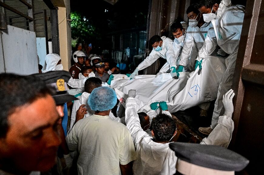 Health care workers in Galle carry the bodies of Iranian sailors who died in a US torpedo attack on their frigate IRIS Dena off Sri Lanka's southern coast