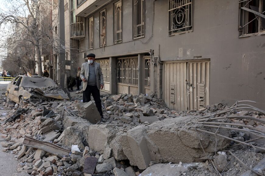 A man makes his way through debris in central Tehran on March 4