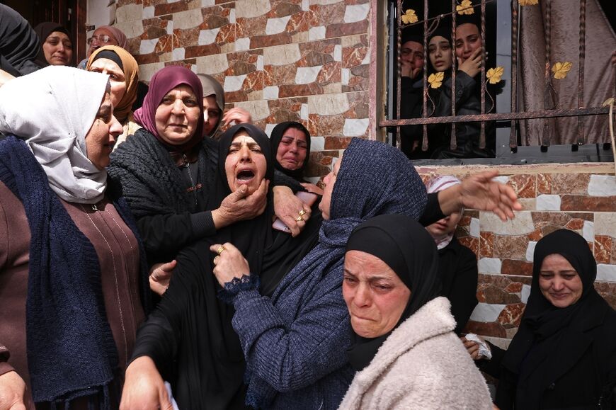 Family members mourn the death of one of three Palestinian women killed in Iranian missile attacks in Beit Awa, a town near the occupied West Bank city of Hebron on March 19, 2026