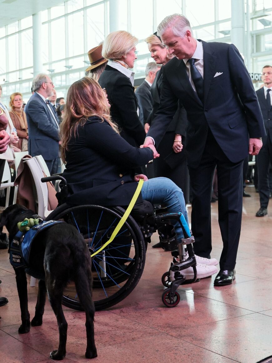 King Philippe shakes hands with Beatrice de Lavalette, who became a Paralympic horse rider after losing her legs in the bombings