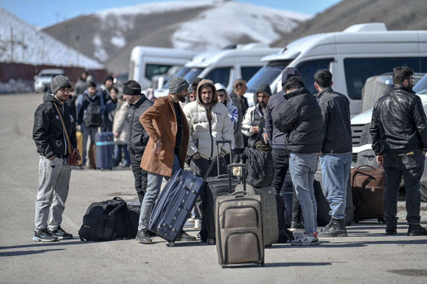 Iranian nationals wait for busses in Turkey after passing through the Razi-Kapiköy border crossing in Van, north-eastern Turkey, on March 3, 2026, a day after Turkey and Iran have mutually suspended day-trip crossings at their border as Israeli-US strikes continued to pound the Islamic Republic. (Photo by Ali IHSAN OZTURK / AFP via Getty Images)