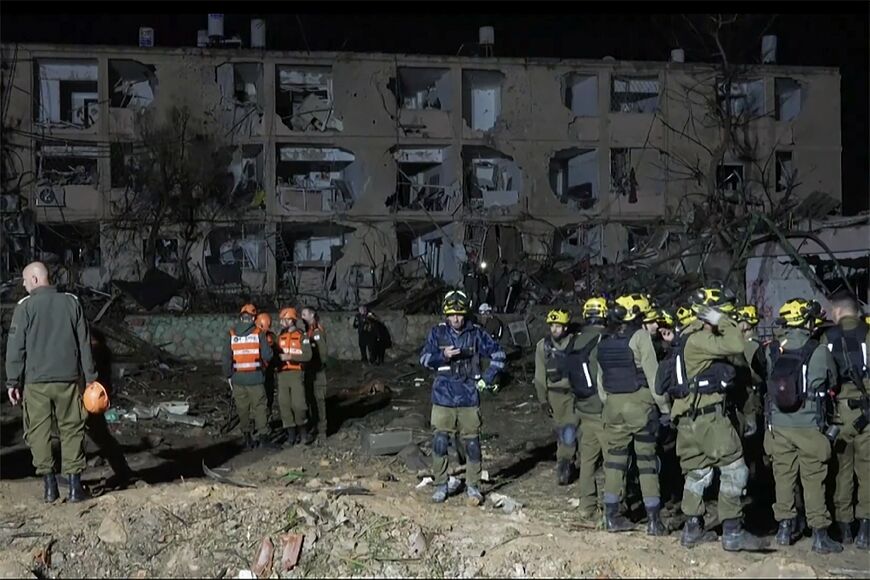 This frame grab from AFPTV footage shows first responders inspecting the site of an Iranian missile strike in Dimona on March 21, 2026
