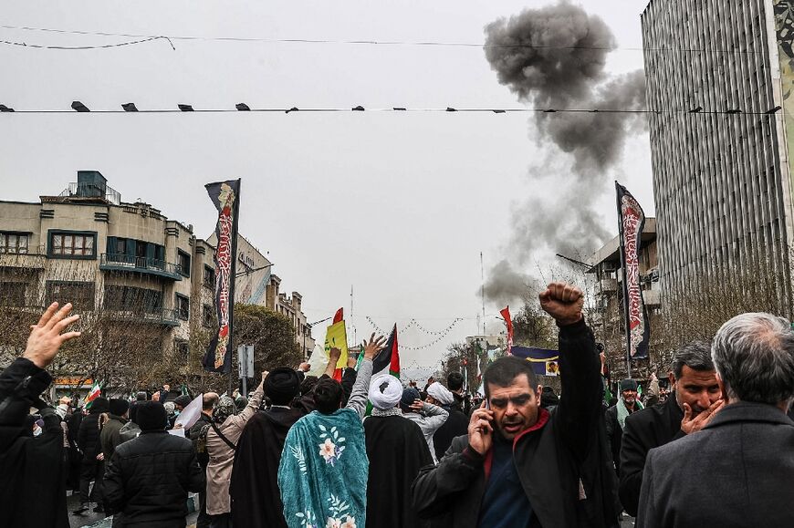 Black smoke rises after an airstrike in Tehran as Iranians take part in the Al-Quds (Jerusalem) Day rally on March 13, 2026