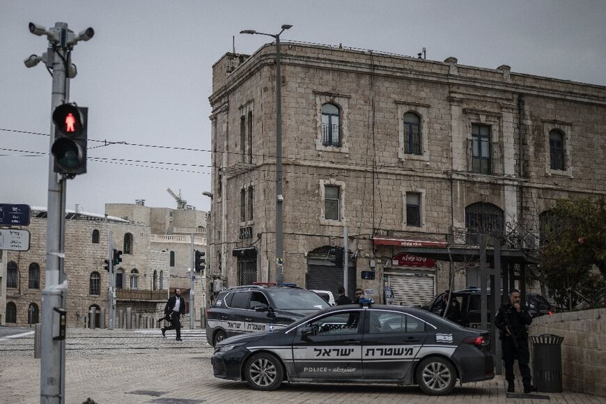 An ultra-Orthodox Jewish man runs for cover as Israeli policemen stand by during an incoming missile attack in Jerusalem