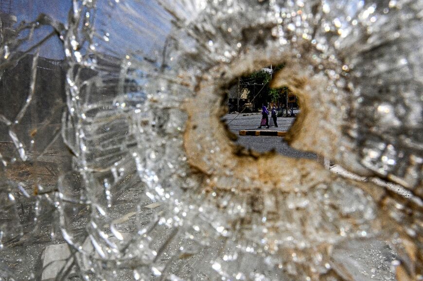 A bullet hole in the shattered glass of a damaged building in the Sudanese capital Khartoum