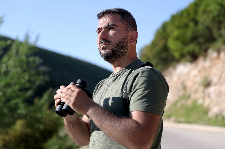 Ornithologist Xhemal Xherri observes birds in the mountains near Tepelene