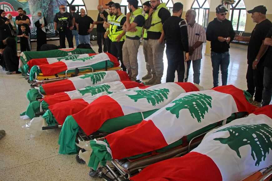 The bodies of people killed in Israeli strikes are seen wrapped in Lebanon flags before their funeral in Tyre