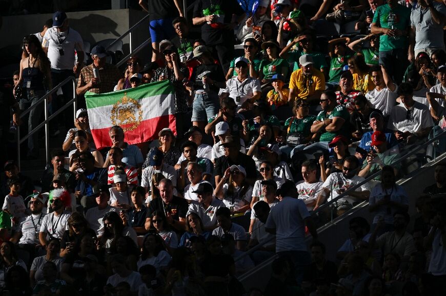 Iranian fans show a pre-revolutionary Iranian flag as they cheer during the 2026 World Cup Group G football match between Iran and New Zealand in Los Angeles