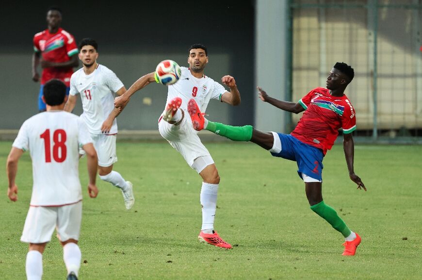 Iran's Mehdi Taremi fights for the ball with Gambia's Mahmudu Bajo during a friendly between the two teams in Antalya on May 29 