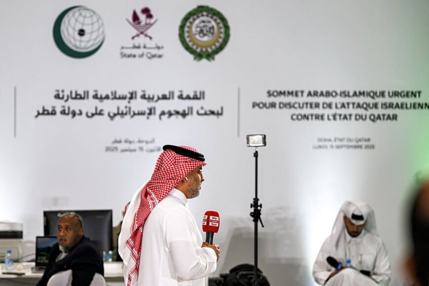 A reporter for Sky News Arabia television channel speaks before the camera from the media centre set up for the 2025 ArabIslamic extraordinary summit in Doha on September 15, 2025. (Photo by MAHMUD HAMS/AFP via Getty Images)