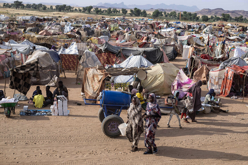 Displaced Sudanese who fled El-Fasher after the city fell to the Rapid Support Forces (RSF), walk in the Um Yanqur camp, located on the southwestern edge of Tawila, in war-torn Sudan's western Darfur region on November 3, 2025. (Photo by AFP via Getty Images)