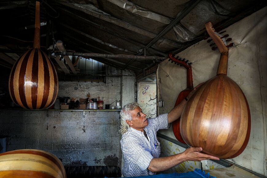 Displaced Palestinian craftsman Suhail Abu Shawish repairs damaged Ouds at a workship in Nuseirat refugee camp in Gaza