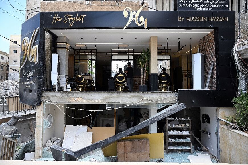 Barber Hussein Hassan was welcoming customers recently, despite the front of his shop being blown off