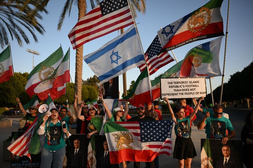 People hold pre-revolutionary Iranian flags as they protest the Iranian regime outside a training session for Iran's team in Los Angeles 