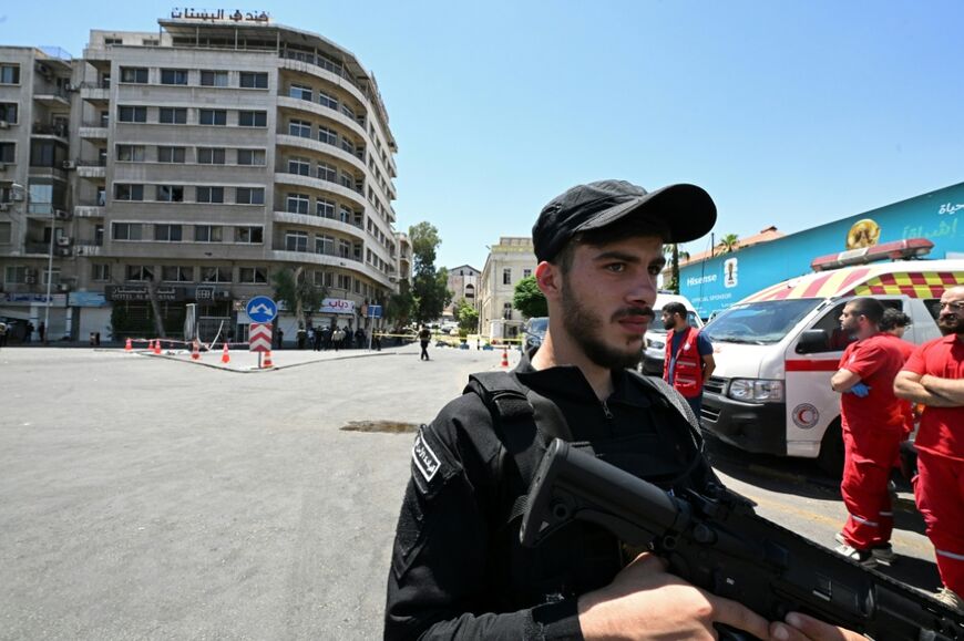 The blasts wounded 18 people, including four police officers, Syrian state media says