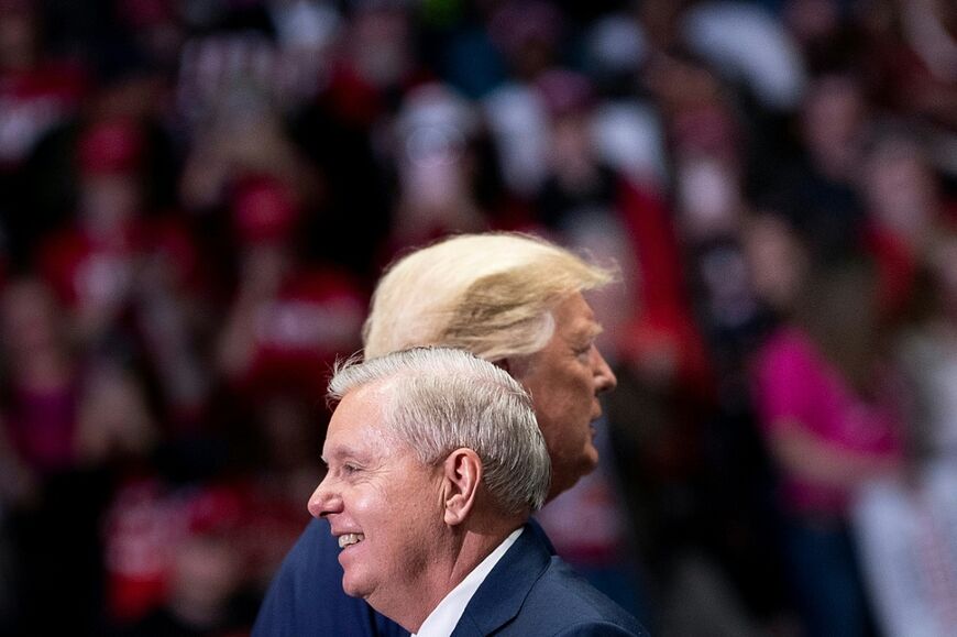 Senator Lindsey Graham (R-SC) arrives to speak with US President Donald Trump (R) during a rally at Bojangles' Coliseum in 2020