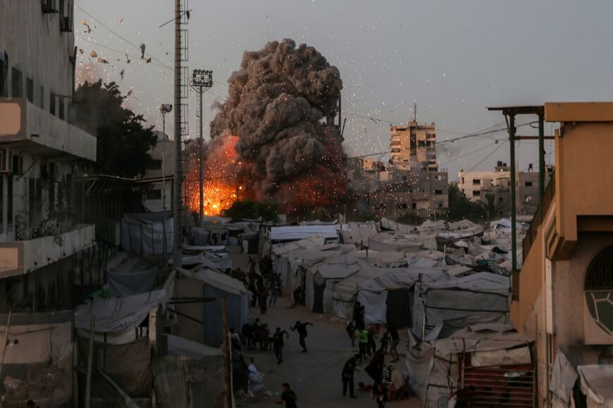 Palestinians run for cover as smoke and fire rise during an Israeli strike on the the Al-Muttaqin Mosque in Gaza City on July 28, 2026